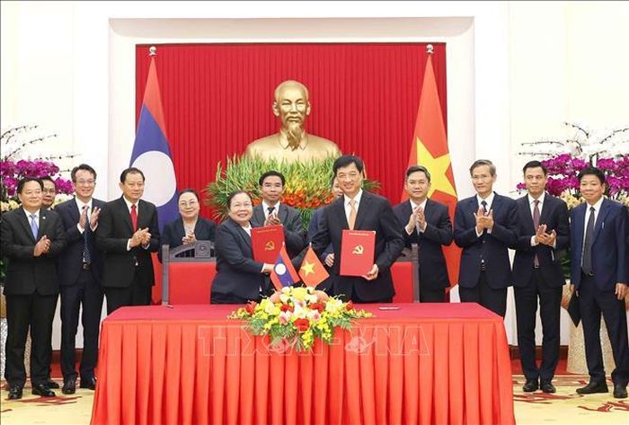 Trưởng Ban Tổ chức Trung ương Nguyễn Duy Ngọc và Trưởng Ban Tổ chức Trung ương Đảng Nhân dân Cách mạng Lào Sisay Leudetmounsone trao Thỏa thuận hợp tác giữa hai cơ quan. Ảnh: Phương Hoa/ TTXVN