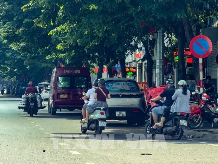 Một xe Limousine dừng, đỗ sát lề đường để đón, trả khách trên tuyến Giải Phóng, tiềm ẩn nguy cơ gây cản trở giao thông. Ảnh: Trung Nguyên - TTXVN