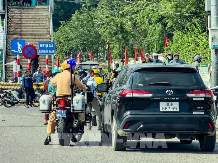 Tổ công tác Đội CSGT đường bộ số 4 tiếp cận, kiểm tra phương tiện có dấu hiệu dừng, đỗ trái quy định tại khu vực nút giao Đại La - Phố Vọng. Ảnh: Trung Nguyên - TTXVN