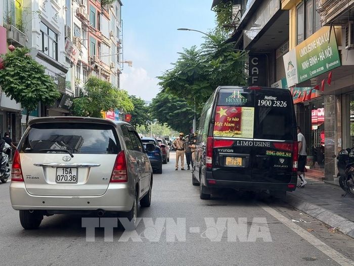 Lực lượng CSGT Đội CSGT đường bộ số 4 tuần tra, phát hiện xe Limousine dừng, đỗ trái quy định để đón, trả khách trên tuyến đường Giải Phóng. Ảnh: Trung Nguyên - TTXVN