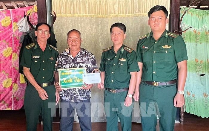 Thăm hỏi, tặng quà cán bộ là thân nhân thương binh, liệt sĩ. Ảnh: Mai Trang - TTXVN