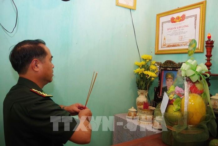 Đại tá Lê Hồng Tuyên, Phó Chính ủy BĐBP thành phố Huế thắp hương tưởng niệm liệt sĩ Lê Đình Tư. Ảnh: Mai Trang - TTXVN