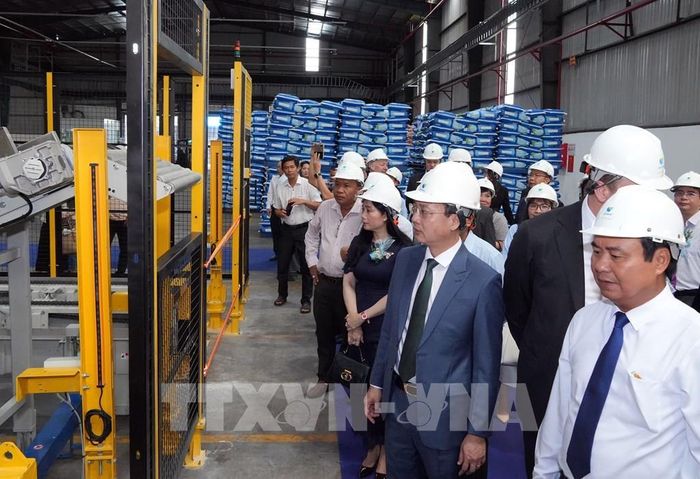 Lãnh đạo tỉnh Vĩnh Long tham quan khu vực sản xuất của Nhà máy thức ăn cá biển và cá nước lạnh của Tập đoàn Hoàng gia De Heus (Hà Lan) tại tuyến công nghiệp Cổ Chiên, tỉnh Vĩnh Long. Ảnh: Phạm Minh Tuấn - TTXVN
