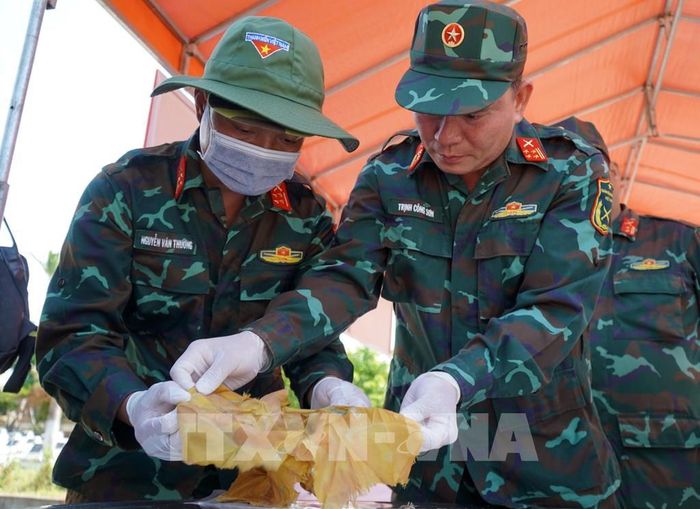 Rà soát, thống kê số lượng di vật tìm thấy tại mộ phần số 115, Nghĩa trang liệt sĩ Đức Minh, xã Mỏ Cày. Ảnh: Lê Phước Ngọc/TTXVN 