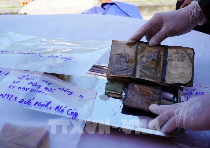 Chiếc ví chứa 2 bức ảnh chân dung (một nam, một nữ) được phát hiện tại mộ phần số 115, Nghĩa trang Liệt sĩ Đức Minh, xã Mỏ Cày. Ảnh: Lê Phước Ngọc/TTXVN