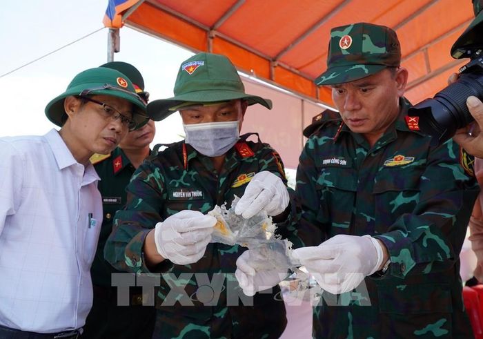 Rà soát, thống kê số lượng di vật tìm thấy tại mộ phần số 115, Nghĩa trang liệt sĩ Đức Minh, xã Mỏ Cày. Ảnh: Lê Phước Ngọc/TTXVN 