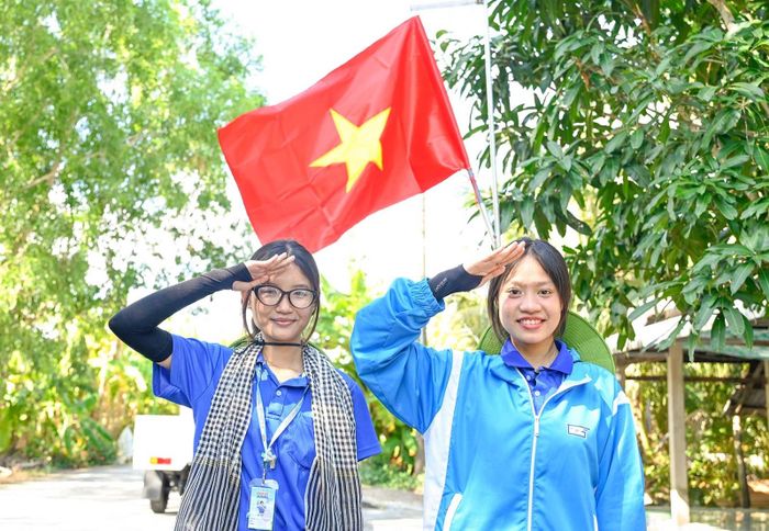Chiến sĩ tình nguyện chụp ảnh lưu niệm bên cờ Tổ quốc.