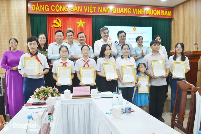 Lãnh đạo Ban Tuyên giáo và Dân vận Thành ủy cùng phụ huynh chúc mừng các em được tuyên dương “Học giỏi - Sống tốt”. Ảnh: Phương Hằng