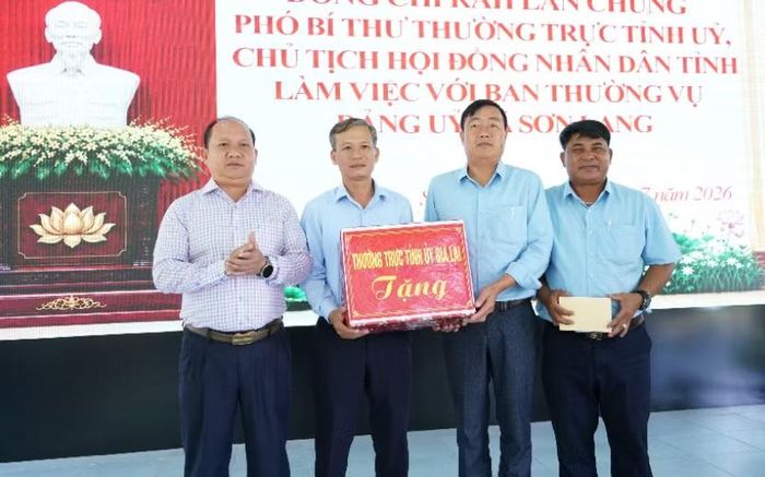  Phó Bí thư Thường trực Tỉnh ủy Rah Lan Chung (bên trái) trao quà cho Ban Thường vụ Đảng ủy xã Sơn Lang. Ảnh: N.H 