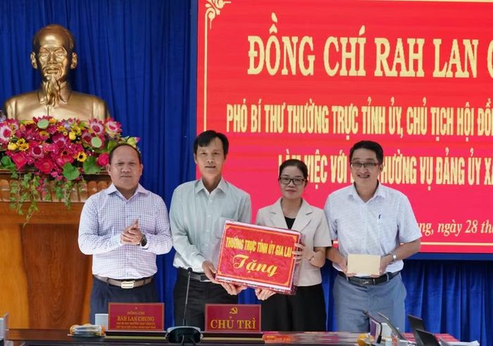  Phó Bí thư Thường trực Tỉnh ủy Rah Lan Chung tặng quà cho Ban Thường vụ Đảng ủy xã Kbang. Ảnh: N.H 