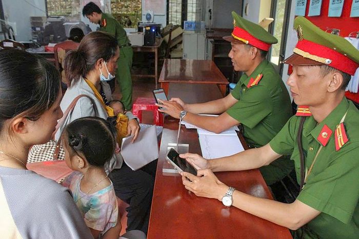 Cán bộ Công an hướng dẫn người dân thực hiện thủ tục trên Cổng dịch vụ công và ứng dụng số. Ảnh Lê Tiến