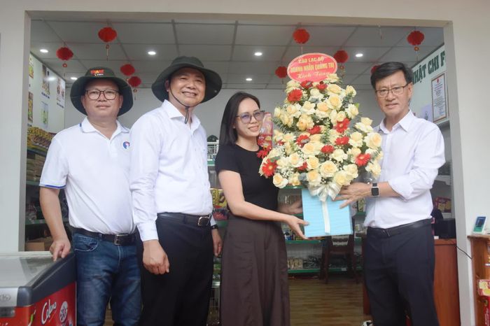 Đại diện Câu lạc bộ Doanh nhân Quảng Trị trao tặng hoa cho cơ sở Nhật Chi Food tại phường Quảng Trị - Ảnh: Đ.V