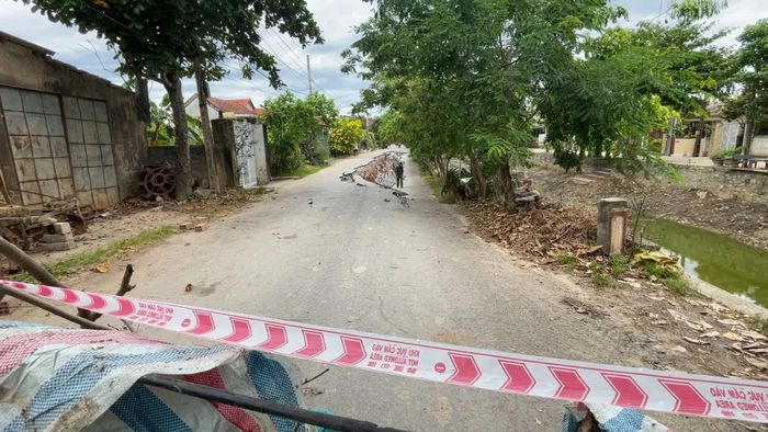 Lực lượng chức năng tiến hành căng dây cảnh báo an toàn ở hai đầu đoạn đường bị sụt lún - Ảnh: N.M.P