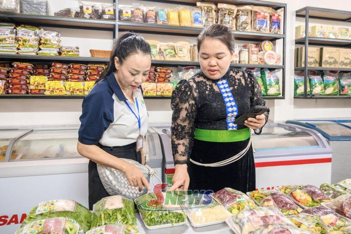 Chị Hoàng Thị Thắm, Phó Giám đốc HTX 26/3, giới thiệu các sản phẩm chế biến sẵn cho khách hàng tại tại Bếp Xanh 26/3.