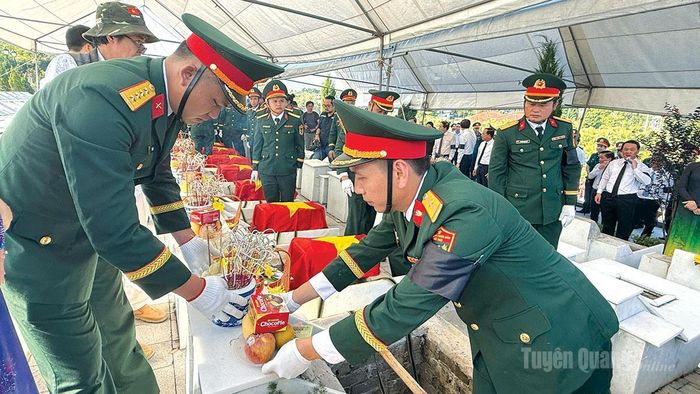 Thực hiện nghi thức an táng hài cốt liệt sĩ.