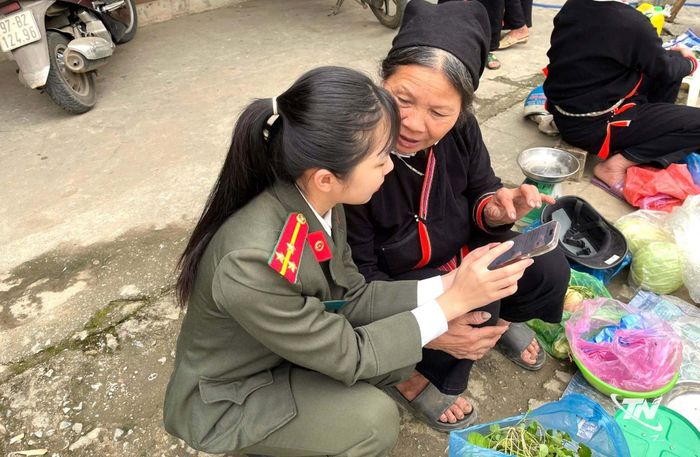 Cán bộ Công an hướng dẫn người dân người dân vùng cao cập nhật thông tin trên điện thoại di động.