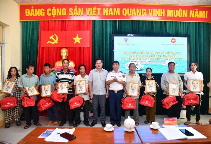 Bộ Tư lệnh Vùng Cảnh sát biển 4 tặng cờ Tổ quốc, ảnh Bác Hồ và túi thuốc y tế cho ngư dân, chủ phương tiện, thuyền trưởng tàu cá. Ảnh: Thanh Điểu