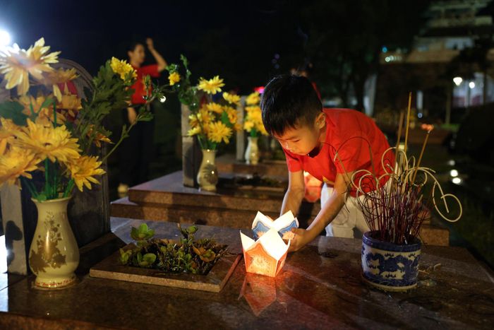 Các em nhỏ thắp sáng những ngọn nến tại các phần mộ liệt sĩ trong Nghĩa trang Liệt sĩ A1.
