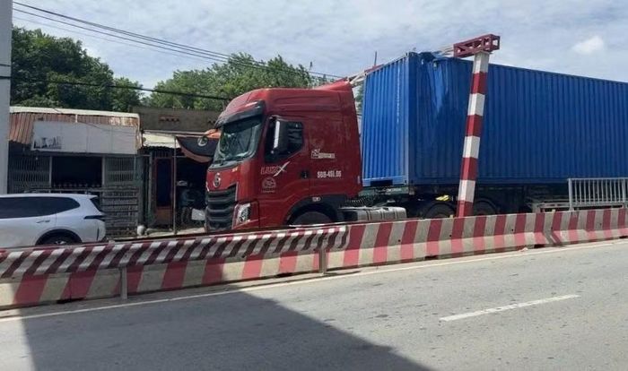 Xe container vượt chiều cao khung bảo vệ cầu đường sắt.
