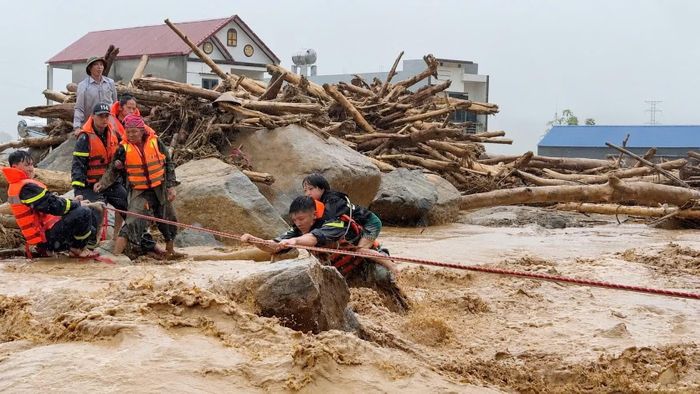  Hạ sĩ Vàng Văn Tình cõng bé gái Lò Thị Yến Thêm vượt lũ. 