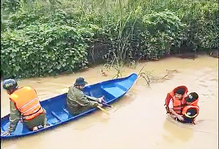 Lực lượng cứu hộ dìu cõng người già, trẻ em tới nơi an toàn.