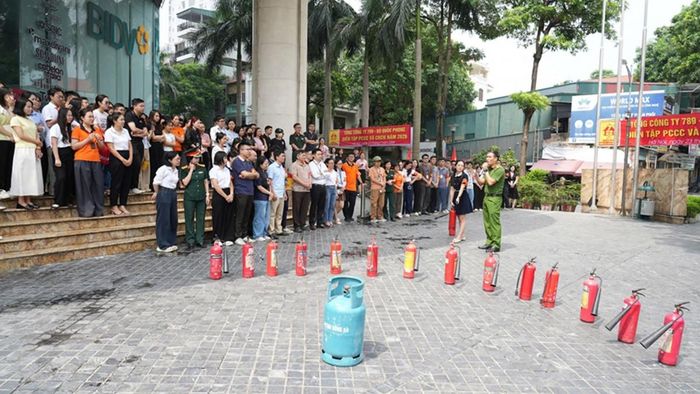 Cán bộ Đội CC&amp;CNCH khu vực số 11 hướng dẫn học viên sử dụng bình chữa cháy xách tay. Ảnh: Tổng công ty 789