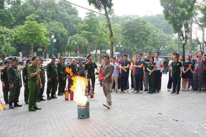 Hướng dẫn học viên trực tiếp sử dụng bình chữa cháy xách tay để dập tắt đám cháy. Ảnh: Tổng công ty 789