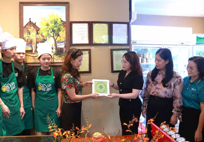 Phó Chủ tịch UBND phường Cửa Nam Trịnh Ngọc Trâm trao biển nhận diện cho các cơ sở kinh doanh. Ảnh: PV