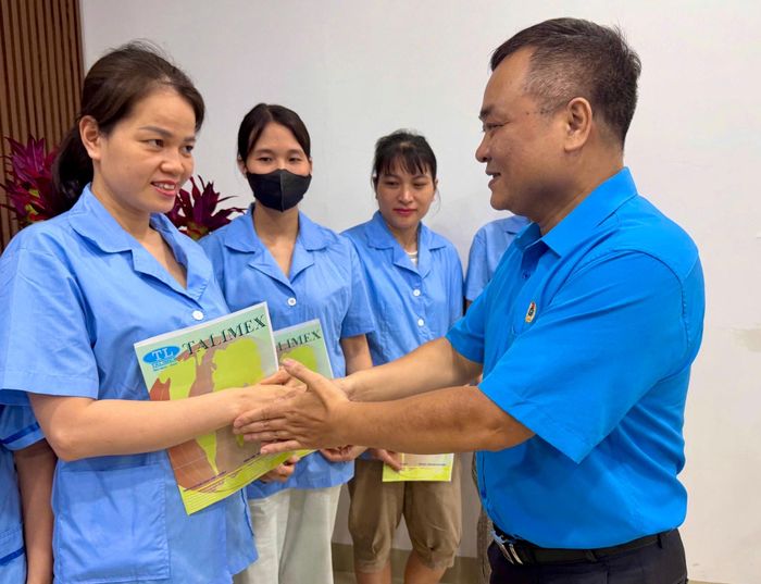 Chủ tịch Công đoàn phường Ô Chợ Dừa Nguyễn Quý Tùng trao Quyết định kết nạp đoàn viên Công đoàn cho người lao động tại doanh nghiệp trên địa bàn. Ảnh: Võ Giang