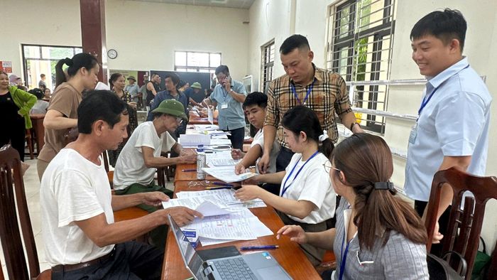 Đại diện các hộ gia đình hoàn thiện thủ tục nhận tiền bồi thường hỗ trợ GPMB dự án Khu đô thị thể thao Quốc tế Hà Nội chiều 28-7. Ảnh: PV