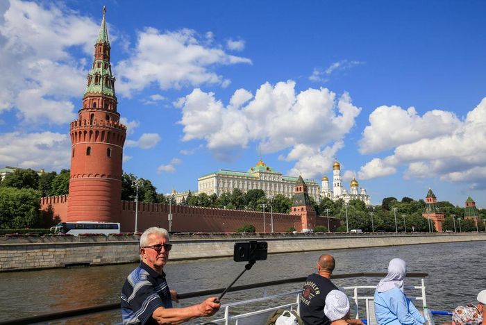 Du khách ngắm nhìn quần thể kiến trúc Điện Kremlin từ tàu du lịch trên sông Moskva. Ảnh: Văn Hiếu - PV TTXVN tại Nga