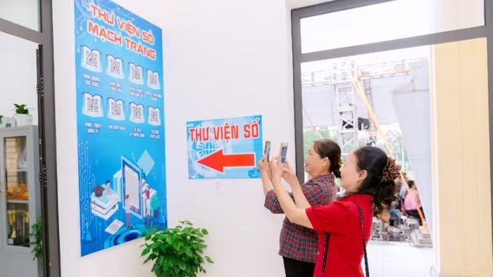 Người dân thôn Mạch Tràng (xã Đông Anh) hào hứng quét mã QR để sử dụng thư viện số của thôn.