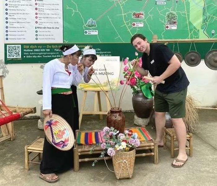 Khách du lịch nước ngoài khám phá văn hóa Mường tại không gian văn hóa du lịch Mường Cốc (xã Mỹ Đức, Hà Nội).