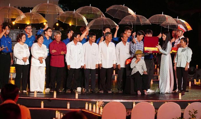 Bà Nguyễn Thị Lệ và gia đình liệt sĩ Huỳnh Văn Quên trên sân khấu cầu truyền hình “Sao sáng dẫn đường” (điểm cầu Công viên Lê Thị Riêng). Ảnh: HÙNG KHOA