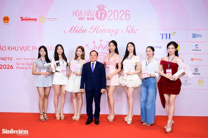 Dàn nữ sinh AOF chụp ảnh cùng nhà báo Lê Xuân Sơn - nguyên Tổng Biên tập Báo Tiền Phong, Trưởng Ban Cố vấn cuộc thi 'Hoa hậu Việt Nam 2026'.