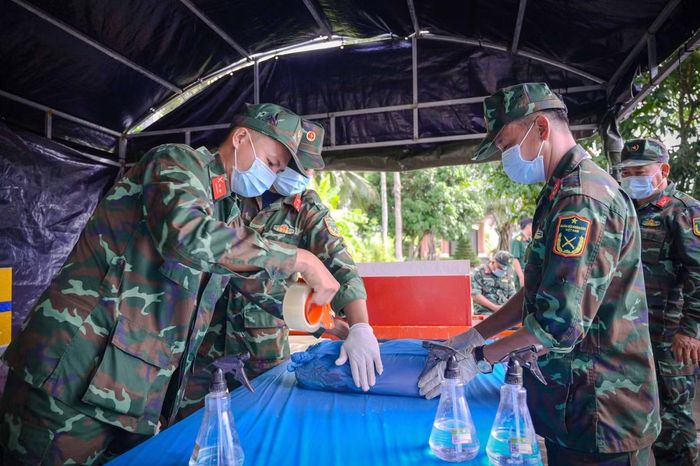 Lực lượng quân đội, y tế và các đơn vị chuyên môn phối hợp thực hiện lấy mẫu hài cốt liệt sĩ. Ảnh: Phương Vũ.