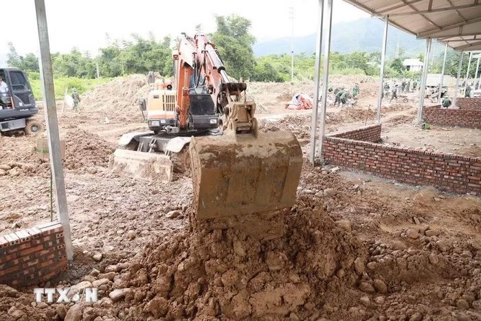 Máy xúc san gạt nền, móng nhà làm việc liên tục để đẩy nhanh tiến độ, góp phần sớm hoàn thành những căn nhà cho người dân vùng lũ Mường Than. (Ảnh: Quý Trung/TTXVN)