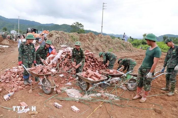 Cán bộ chiến sỹ, học viên cùng chung sức hoàn thành những căn nhà để giúp người dân vùng lũ ổn định cuộc sống. (Ảnh: Quý Trung/TTXVN)