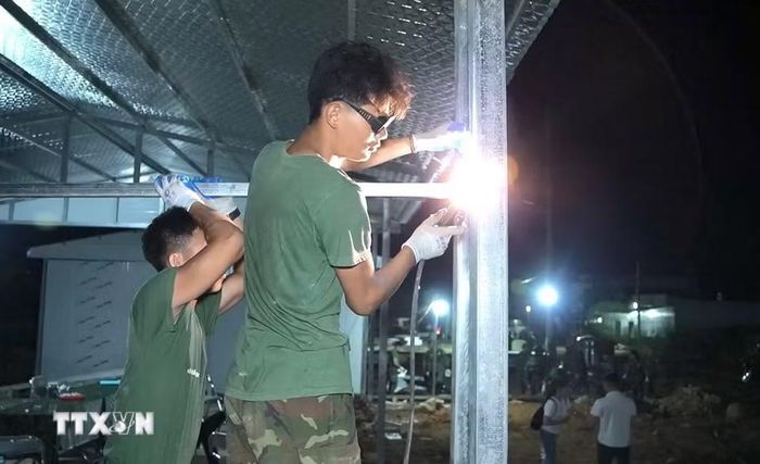 Cán bộ chiến sỹ làm xuyên ngày đêm với mục tiêu chung sớm dựng xong những căn nhà cho người dân vùng lũ Mường Than. (Ảnh: Quý Trung/TTXVN)