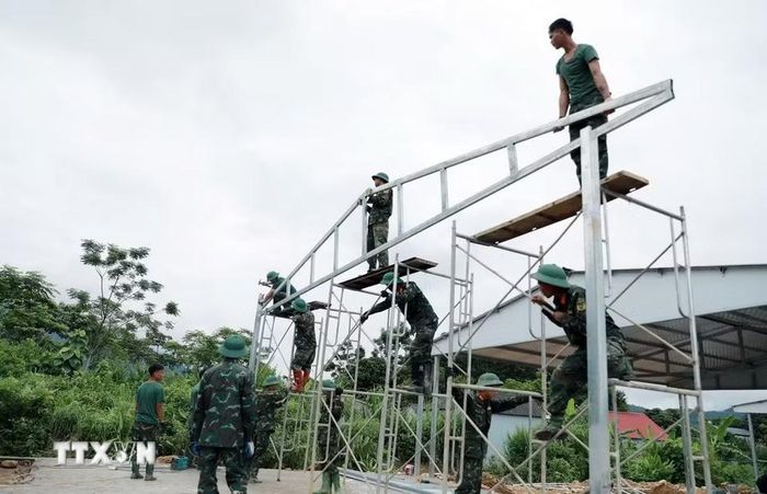Những khung nhà dành cho người dân vùng lũ Mường Than nối tiếp nhau mọc lên từng giờ tại khu tái định cư bản Sân Bay. (Ảnh: Quý Trung/TTXVN)