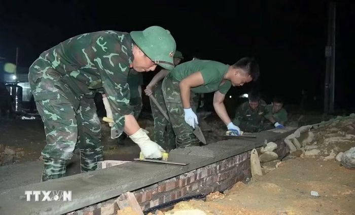 Cán bộ chiến sỹ thi công thần tốc vượt thời gian xây nhà dành cho người dân vùng lũ Mường Than, Lai Châu. (Ảnh: Quý Trung/TTXVN)