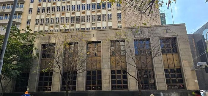 Cận cảnh mặt tiền tòa nhà Nedbank với kiến trúc đá khối kiên cố, các khung cửa sổ kim loại chạm khắc phù điêu cổ điển – đặc trưng cho phong cách kiến trúc ngân hàng thập niên giữa thế kỷ 20. (Ảnh: Hồng Minh/Vietnam+)