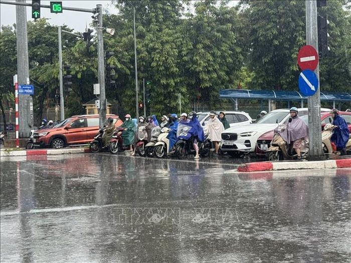 Người dân di chuyển khó khăn trong trận mưa lớn trên diện rộng tại Hà Nội sáng 29/7/2026. Ảnh: Quốc Lũy/TTXVN