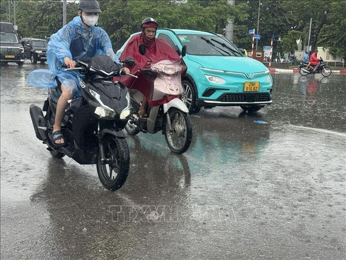 Người dân di chuyển khó khăn trong trận mưa lớn trên diện rộng tại Hà Nội sáng 29/7/2026. Ảnh: Quốc Lũy/TTXVN