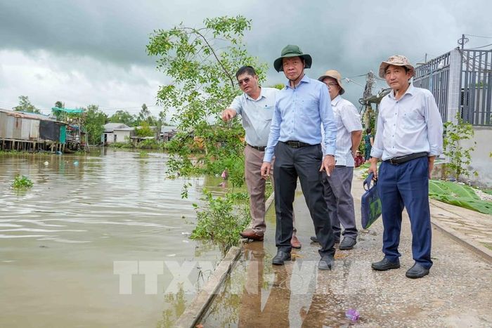 Ông Nguyễn Tấn Nhơn (giữa), Phó Giám đốc Sở Nông nghiệp và Môi trường thành phố Cần Thơ, khảo sát điểm sạt lở bờ rạch Mang Cá gần UBND xã Đại Hải. Ảnh: Thanh Liêm - TTXVN