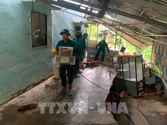 Lực lượng chức năng xã Cát Tiên (Lâm Đồng) hỗ trợ người dân di dời tài sản và bố trí nơi ở tạm để bảo đảm an toàn trước nguy cơ sạt lở. Ảnh: TTXVN phát