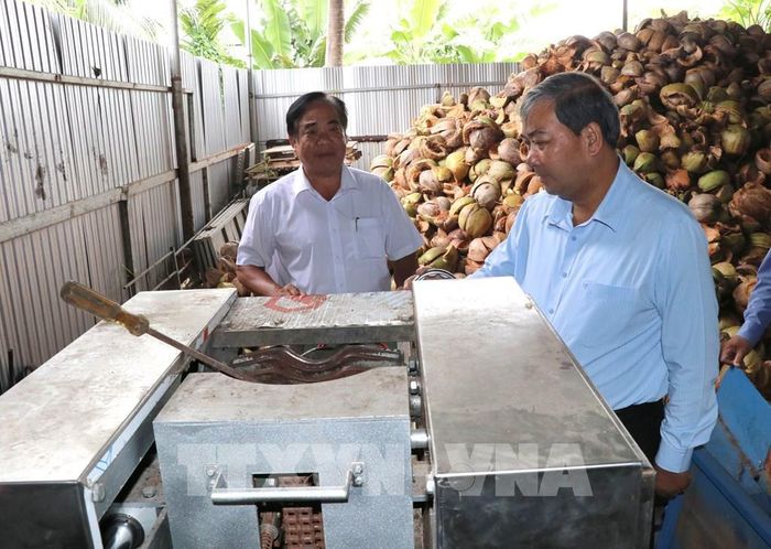 Phó Bí thư Tỉnh ủy, Chủ tịch Ủy ban MTTQ Việt Nam tỉnh Vĩnh Long Kim Ngọc Thái (phải) khảo sát máy móc tại Hợp tác xã nông nghiệp Vạn Hưng, xã Bình Phú. Ảnh: Thanh Hòa - TTXVN