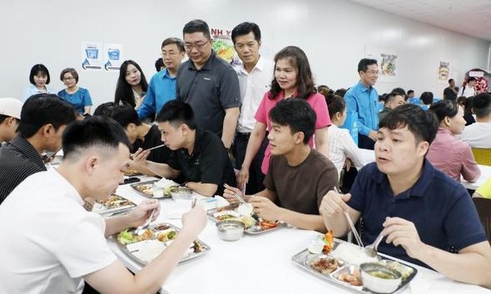  Các đại biểu trò chuyện với công nhân lao động tại chương trình "Bữa cơm công đoàn". 