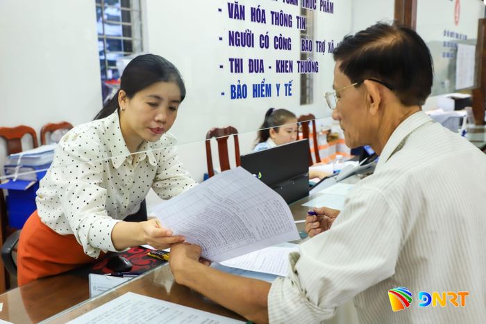 Cán bộ phường Hòa Khánh hướng dẫn người dân làm thủ tục. Ảnh: NGỌC PHÚ