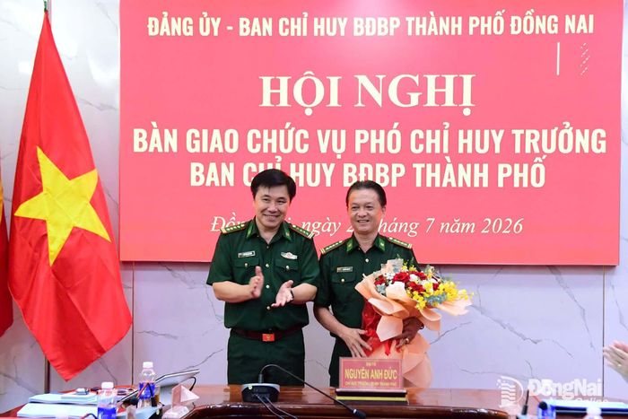 Đại tá Nguyễn Anh Đức, Ủy viên Thường vụ Đảng ủy Quân sự, Phó Chỉ huy trưởng Bộ Chỉ huy Quân sự thành phố Đồng Nai kiêm Chỉ huy trưởng Ban Chỉ huy Bộ đội Biên phòng thành phố tặng hoa chúc mừng Đại tá Nguyễn Ngọc Út. Ảnh: Tú Trịnh